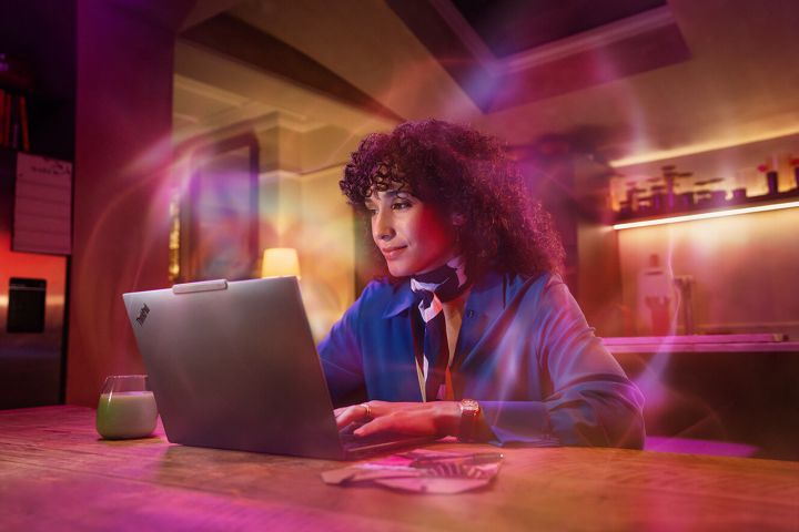 Mulher usando um notebook Aura com uma névoa roxa ao redor dela.